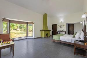 a large bedroom with a bed and a fireplace at VANVASA RESORTs in Kānda +14 photos