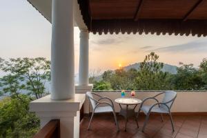 a patio with two chairs and a table on a balcony at VANVASA RESORTs in Kānda