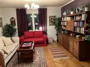 a living room with a red couch and a book shelf at Large family housing in Mariannelund
