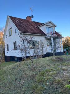 an old white house on top of a hill at Large family housing in Mariannelund