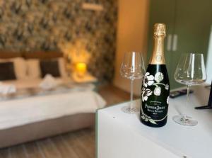 a bottle of champagne and two wine glasses on a table at Bottega del Sogno in Alice Bel Colle