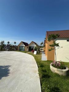 a house with a driveway next to a building at บ้านสุดซอย-Baan Sud Soi in Prachuap Khiri Khan