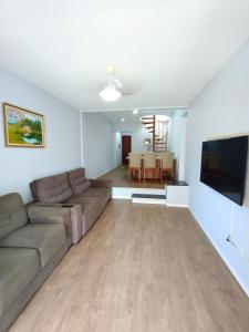 a living room with a couch and a flat screen tv at Duplex 11 Pessoas-Churrasqueira-Próximo ao Mar in Itapema