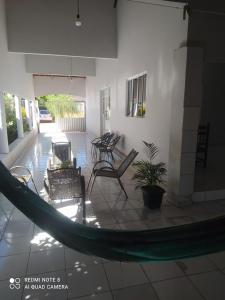 a hammock in a room with chairs and a patio at casa Beija Flor in Riachão