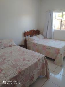 a bedroom with two beds and a window at casa Beija Flor in Riachão