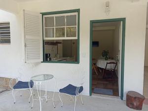 a patio with a table and chairs and a window at Sítio Canto das Águas in Petrópolis +31 photos