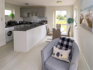a kitchen and living room with a couch and a table at Sunset Sands in Deganwy