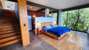 a bedroom with a blue bed in a room with windows at Utopia Casas Boutique in Oaxaca City