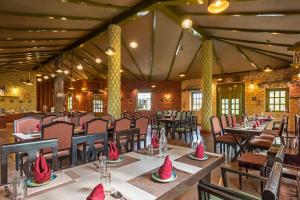a restaurant with tables and chairs with red hats on them at VANVASA RESORTs in Kānda