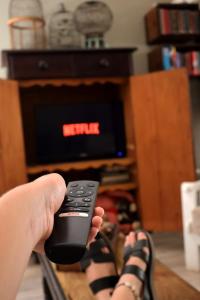 a person holding a remote control in front of a tv at The Calitz in Calitzdorp