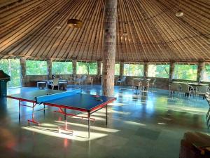 a ping pong table in a pavilion with tables and chairs at VANVASA RESORTs in Kānda