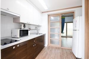a kitchen with a microwave and a refrigerator at Suncheon Bay Ecology Pension in Suncheon