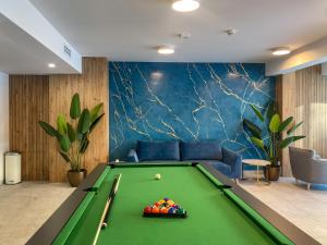 a billiard room with a pool table and a couch at Szum Bałtyku in Jastrzębia Góra