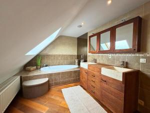 a attic bathroom with a tub and a sink at Cosy Duplex pour 4 personnes à Soignies in Soignies +16 photos