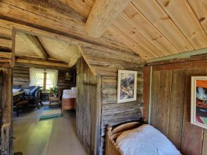 a bedroom in a log cabin with a bed at Smia cabin , A Unique Rustic Hideaway in Lii