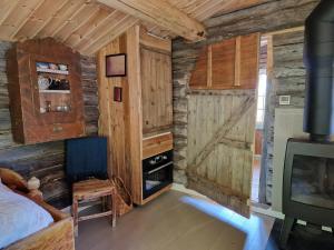 a bedroom with wooden walls and a bed and a tv at Smia cabin , A Unique Rustic Hideaway in Lii