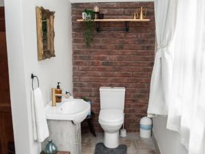 a bathroom with a white toilet and a brick wall at Bluewater Guesthouse in Port Elizabeth +128 photos