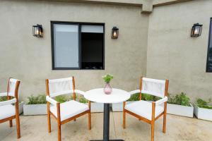 a table with four chairs and a vase on it at Altitude Ambuluwawa in Gampola