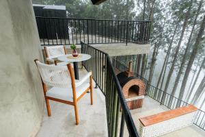 a balcony with a table and a brick oven at Altitude Ambuluwawa in Gampola