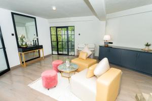 a living room with a white couch and pink chairs at Altitude Ambuluwawa in Gampola
