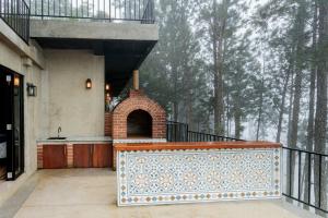a building with a balcony with an outdoor fireplace at Altitude Ambuluwawa in Gampola
