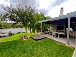 a house with a deck with a table and a grill at Misty Moon in Malgas
