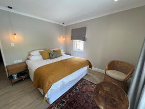 a bedroom with a bed and a table and a chair at Misty Moon in Malgas +14 photos