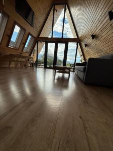 a large room with a couch and tables and windows at Vatra Barsei in Tohanu Nou