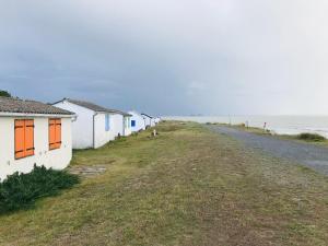 a row of houses on the side of a road next to the ocean at Chalet du Mont-Saint-Michel in Saint-Jean-le-Thomas