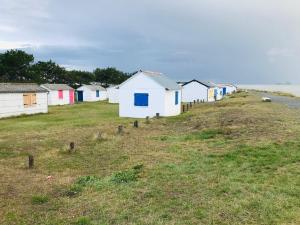 a row of houses sitting on a hill next to the ocean at Chalet du Mont-Saint-Michel in Saint-Jean-le-Thomas +8 photos