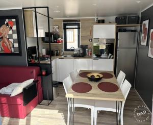 a small kitchen with a table and a dining room at Chalet du Mont-Saint-Michel in Saint-Jean-le-Thomas