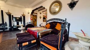 a room with a bed and a table and a mirror at Dar Soulaimane in Marrakesh
