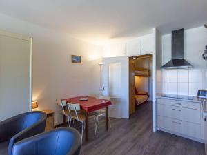 a room with a table and chairs and a kitchen at Studio cosy pour 4 personnes à 150m des pistes - Gourette - FR-1-400-43 in Gourette +4 photos