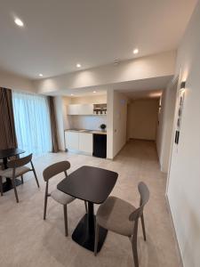 a living room with two tables and chairs and a kitchen at Ab aparthotel in Gizzeria