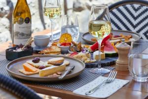 a table with plates of food and glasses of wine at Blaauwklippen Manor by NEWMARK in Stellenbosch