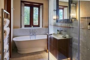 a bathroom with a tub and a sink at Blaauwklippen Manor by NEWMARK in Stellenbosch