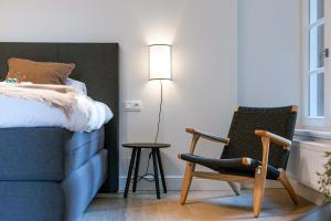 a bedroom with a bed and a chair and a lamp at Apartment near Antwerp Cathedral in Antwerp