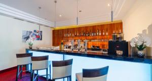 eine Bar in einem Raum mit Hockern in der Unterkunft PLAZA INN Wels in Wels