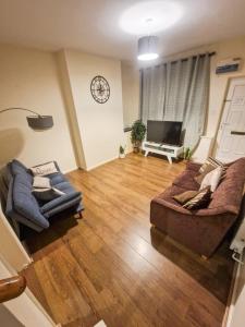 a living room with two couches and a television at Leyland Town Centre Quiet Hub 2 bedroom 4 beds superfast WIFI free parking close to station and High Street in Leyland
