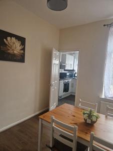 a dining room with a table and a kitchen at Leyland Town Centre Quiet Hub 2 bedroom 4 beds superfast WIFI free parking close to station and High Street in Leyland +16 photos