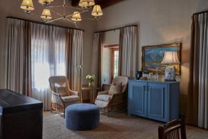 a living room with a blue cabinet and chairs at Blaauwklippen Manor by NEWMARK in Stellenbosch