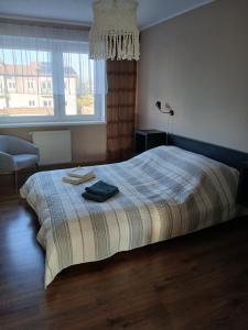 a bedroom with a bed with a blanket and a window at Duży Apartament 75m2 in Wągrowiec