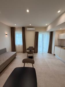 a living room with a couch and two chairs at Ab aparthotel in Gizzeria