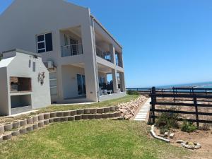 a white house with the ocean in the background at De Santa Villas in St. Helena Bay