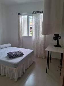 a bedroom with a bed and a window at Casa Lovato in Arroio do Sal