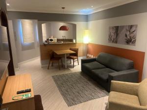 a living room with a couch and a table at Hotel Cosmopolitan Praia Flat in Santos