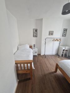 a bedroom with two beds and a wooden floor at Leyland Town Centre Quiet Hub 2 bedroom 4 beds superfast WIFI free parking close to station and High Street in Leyland