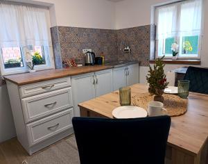 a kitchen with a wooden table and a kitchen with windows at Salaš 1860 - Palić in Palić