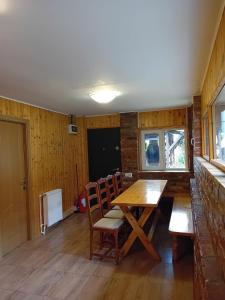 a dining room with a wooden table and chairs at Casuta Azughia in Azuga