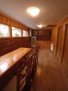 a dining room with a long wooden table and chairs at Casuta Azughia in Azuga +13 photos